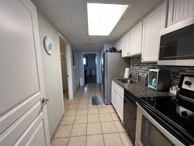 2701 S Ocean Blvd Unit 1507, North Myrtle Beach, SC 29582 - kitchen featuring appliances with stainless steel finishes, a sink, backsplash, white cabinets, and light tile patterned floors