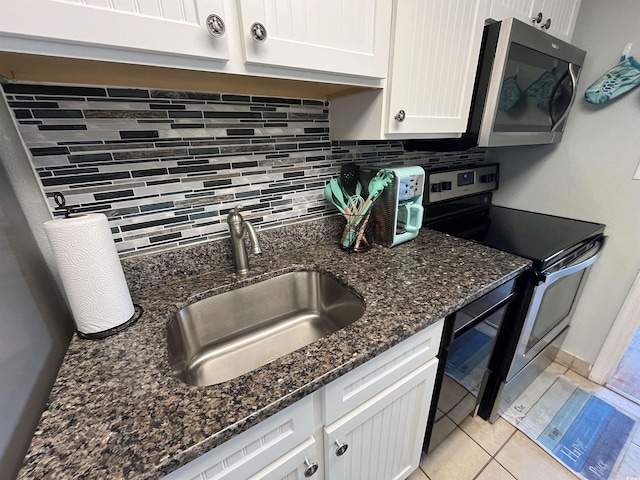 2701 S Ocean Blvd Unit 1507, North Myrtle Beach, SC 29582 - kitchen featuring appliances with stainless steel finishes, a sink, tasteful backsplash, white cabinetry, and dark stone counters