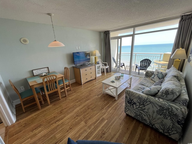 2701 S Ocean Blvd Unit 1507, North Myrtle Beach, SC 29582 - living room featuring wood finished floors, a textured ceiling, floor to ceiling windows, and baseboards