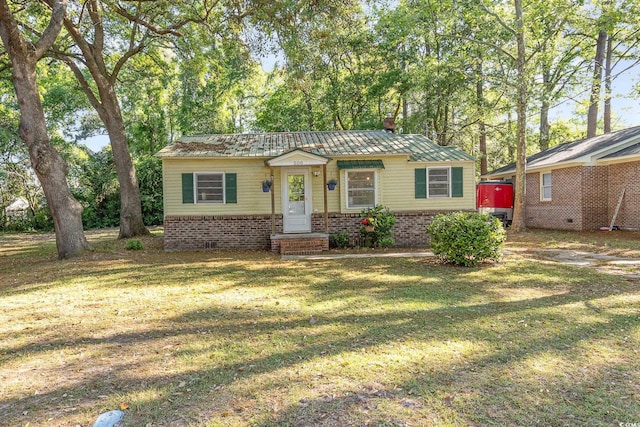 508 Pearl St, Conway, SC 29527 - view of front facade with a chimney, a front yard, and metal roof