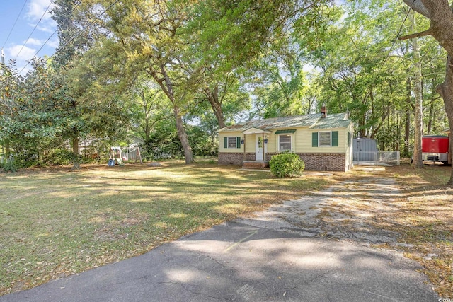 508 Pearl St, Conway, SC 29527 - view of front facade with brick siding, driveway, a playground, and a front yard