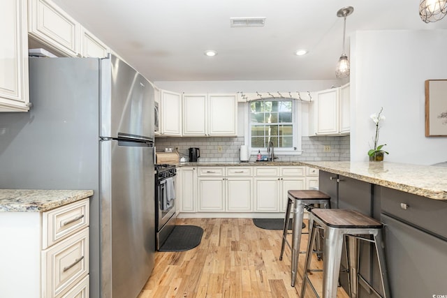 508 Pearl St, Conway, SC 29527 - kitchen with decorative backsplash, appliances with stainless steel finishes, visible vents, and light wood-type flooring