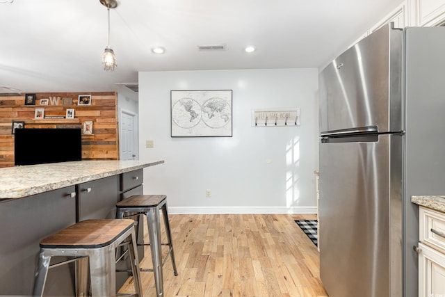 508 Pearl St, Conway, SC 29527 - kitchen with visible vents, freestanding refrigerator, light wood-type flooring, baseboards, and a breakfast bar area