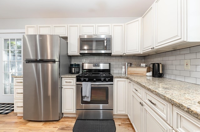 508 Pearl St, Conway, SC 29527 - kitchen with decorative backsplash, light stone counters, stainless steel appliances, and light wood-type flooring