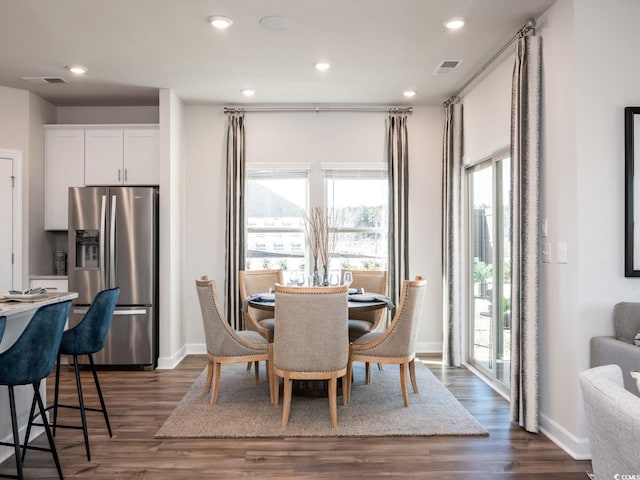 dining space with baseboards, dark wood-type flooring, and visible vents