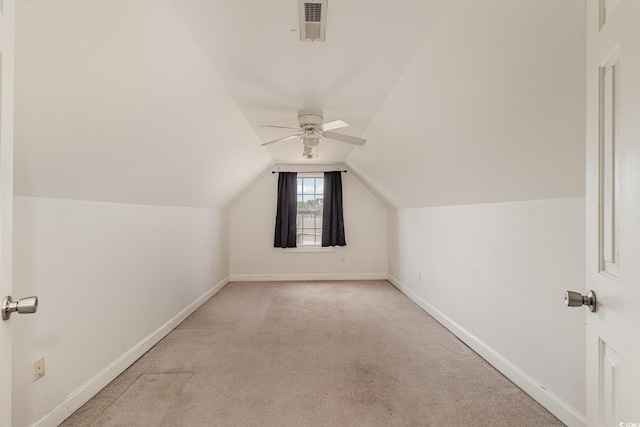 additional living space with lofted ceiling, visible vents, a ceiling fan, baseboards, and light colored carpet