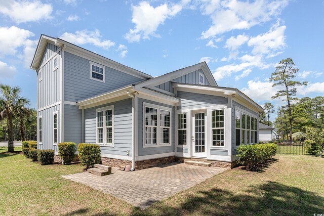 600 Waterbridge Blvd, Myrtle Beach, SC 29579 - back of property featuring board and batten siding, a patio area, a lawn, and fence