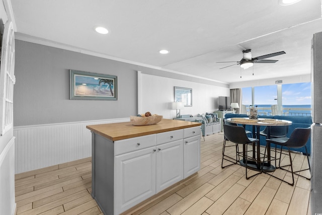 1012 N Waccamaw Dr Unit 507, Murrells Inlet, SC 29576 - kitchen with butcher block counters, a ceiling fan, white cabinets, light wood finished floors, and crown molding