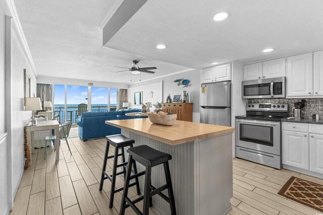 1012 N Waccamaw Dr Unit 507, Murrells Inlet, SC 29576 - kitchen with stainless steel appliances, butcher block countertops, wood finish floors, tasteful backsplash, and open floor plan