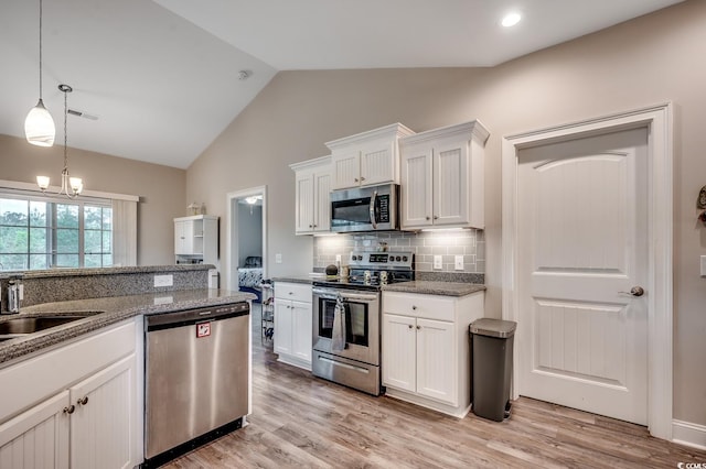 kitchen with white cabinets, stainless steel appliances, visible vents, backsplash, and lofted ceiling