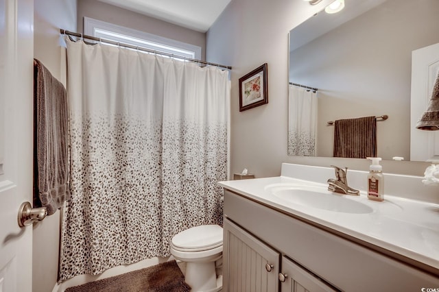 full bath with a shower with curtain, vanity, and toilet