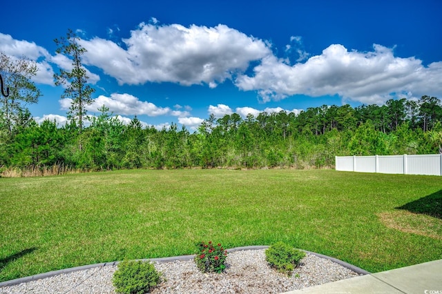 view of yard with fence and a forest view