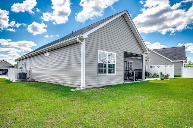 rear view of property with a yard, central AC, and fence
