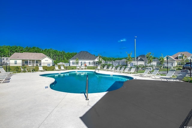 pool featuring fence, a residential view, and a patio