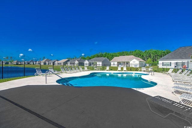 community pool featuring a residential view, a patio, and fence