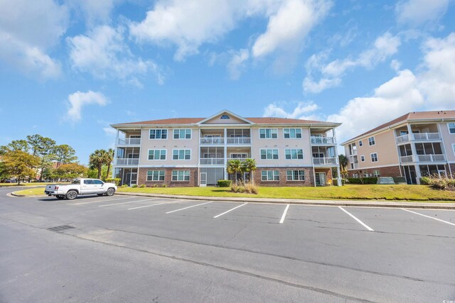 view of building exterior with uncovered parking