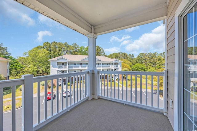 balcony featuring view of wooded area