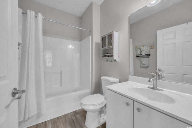 bathroom with shower / bath combination with curtain, toilet, wood finished floors, and vanity