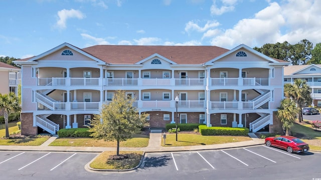 view of property with uncovered parking and stairs