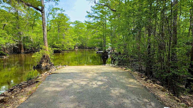 view of patio featuring a water view and a forest view