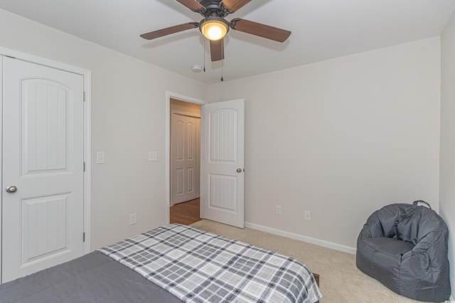 bedroom with light colored carpet, a ceiling fan, and baseboards
