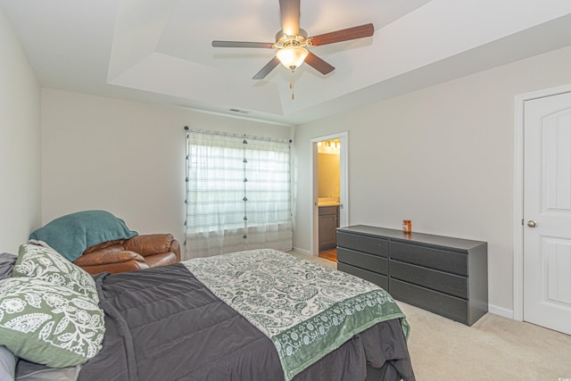bedroom featuring baseboards, a raised ceiling, a ceiling fan, and light colored carpet