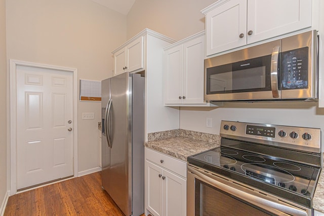 kitchen featuring baseboards, appliances with stainless steel finishes, light countertops, white cabinetry, and dark wood-style floors