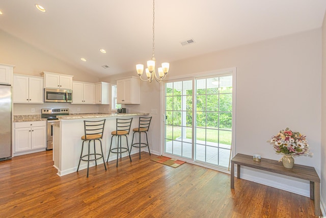 kitchen featuring a chandelier, stainless steel appliances, dark wood-style flooring, and vaulted ceiling