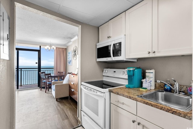 6900 Ocean Blvd N Unit 1114, Myrtle Beach, SC 29572 - kitchen with white appliances, floor to ceiling windows, a chandelier, white cabinets, and a water view