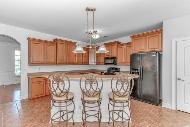 178 Kessinger Dr, Surfside Beach, SC 29575 - kitchen featuring black appliances, light countertops, a center island, arched walkways, and a breakfast bar