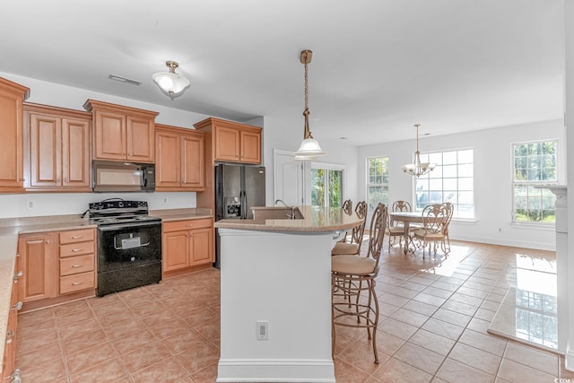 178 Kessinger Dr, Surfside Beach, SC 29575 - kitchen featuring black appliances, a kitchen bar, light countertops, and light tile patterned floors