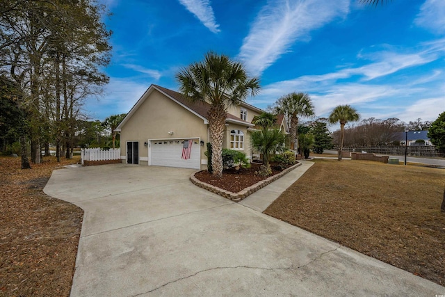 traditional home with an attached garage, stucco siding, fence, and concrete driveway