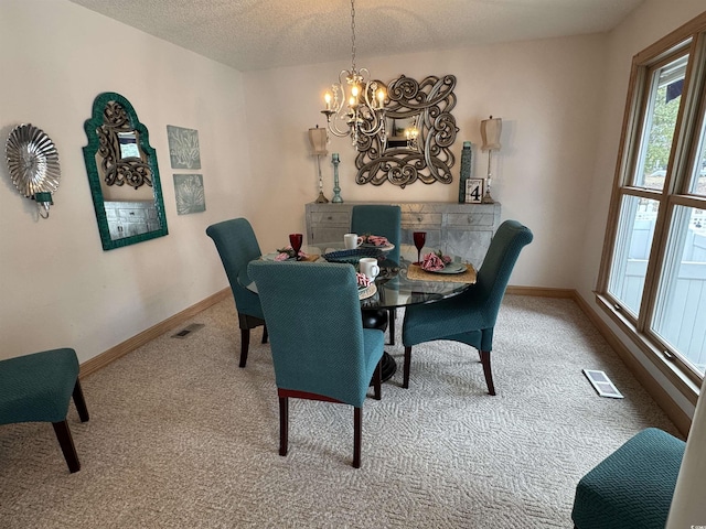 carpeted dining area with visible vents, a textured ceiling, baseboards, and an inviting chandelier