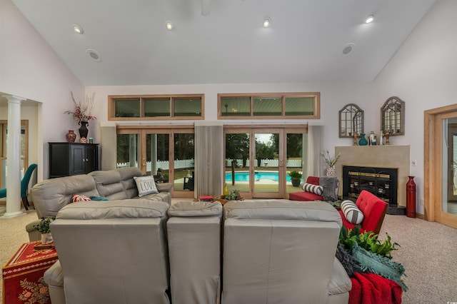 living area with a high end fireplace, high vaulted ceiling, carpet flooring, and ornate columns