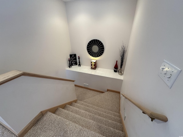 stairway with baseboards and carpet flooring