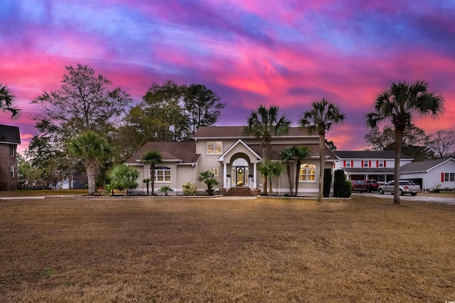 view of front of property featuring a lawn and stucco siding