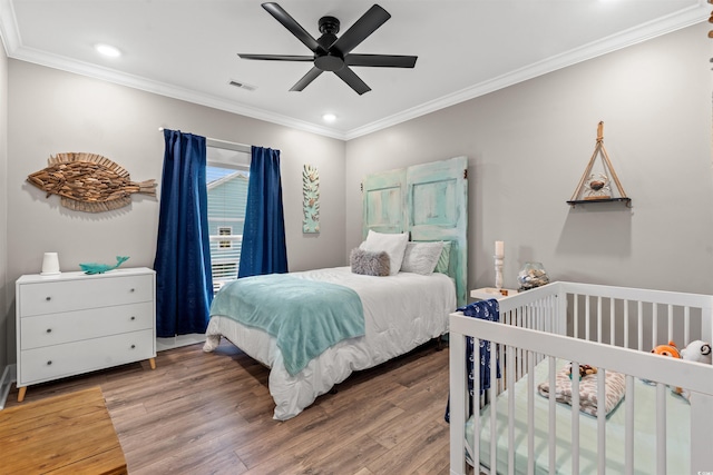 bedroom featuring wood finished floors, a ceiling fan, visible vents, ornamental molding, and recessed lighting