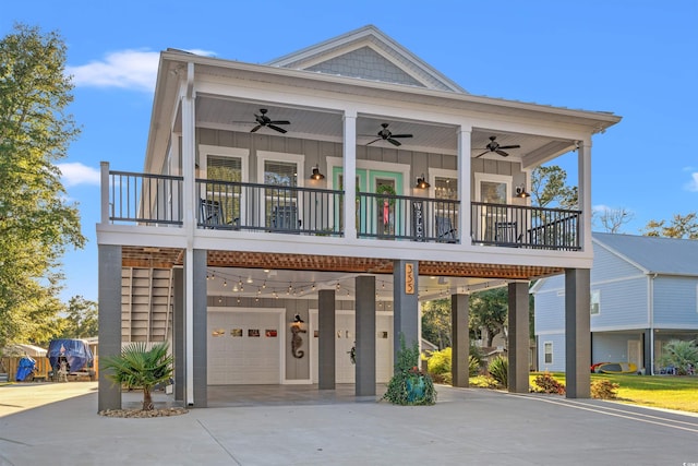 coastal inspired home featuring concrete driveway, board and batten siding, a garage, and a ceiling fan