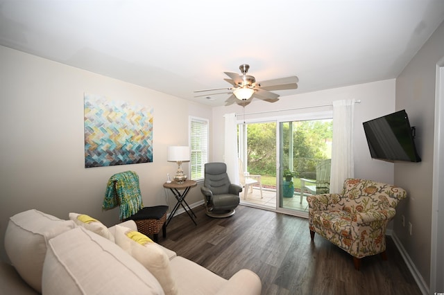 living area with wood finished floors, a ceiling fan, and baseboards