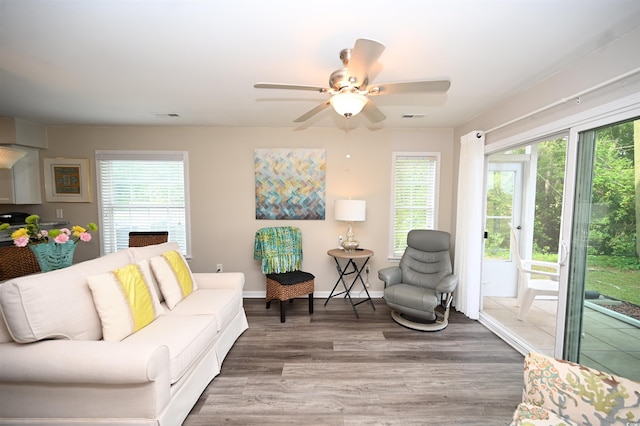living room featuring visible vents, plenty of natural light, a ceiling fan, and wood finished floors