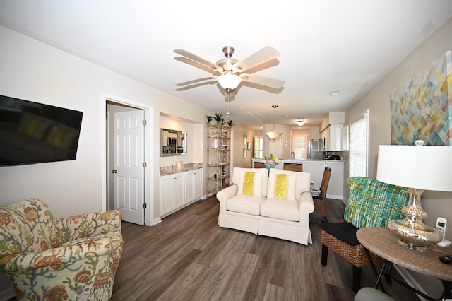 living area with ceiling fan and dark wood-style floors