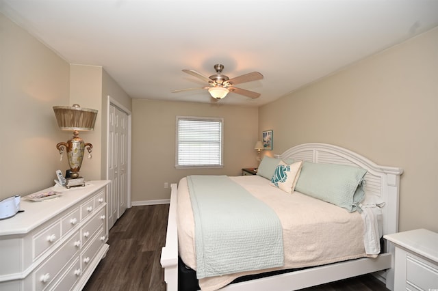 bedroom with ceiling fan, baseboards, dark wood-type flooring, and a closet