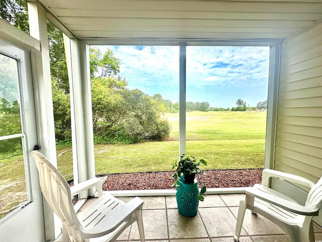 sunroom / solarium featuring golf course view and a healthy amount of sunlight