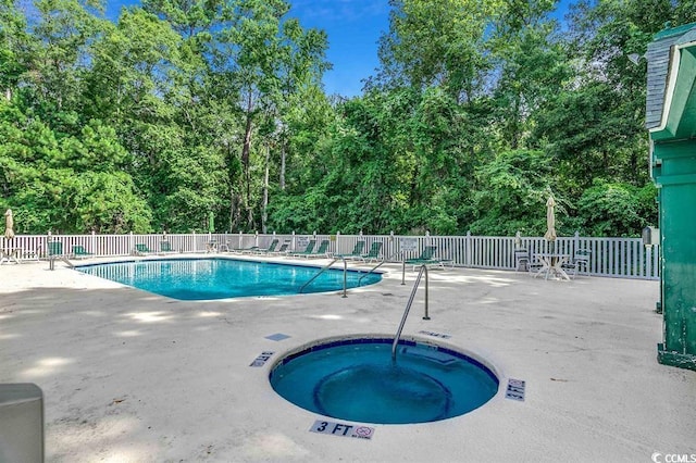 pool featuring fence, a community hot tub, and a patio area