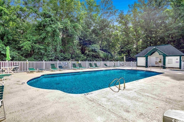 community pool featuring fence and a patio