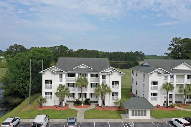 view of front of house featuring uncovered parking and a front lawn