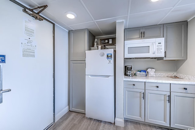 7100 N Ocean Blvd Unit 801, Myrtle Beach, SC 29572 - kitchen with white appliances, gray cabinets, light wood finished floors, and light countertops