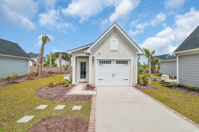 view of front of house featuring board and batten siding, a front yard, driveway, and a garage