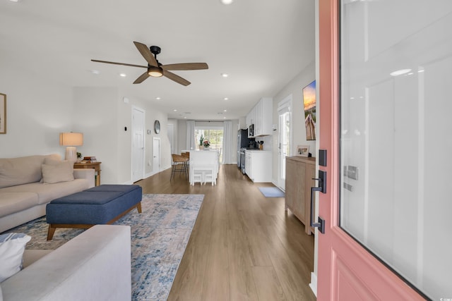 living room featuring ceiling fan, light wood-style floors, and recessed lighting