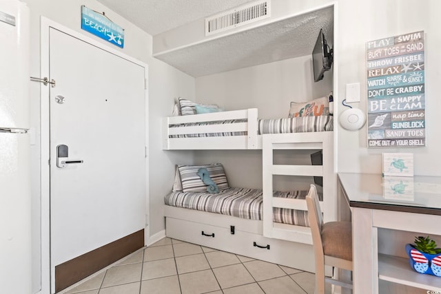 tiled bedroom featuring a textured ceiling and visible vents